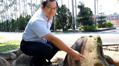 關西高中校長吳原榮意外在校園樹叢內，發現多年前畢業生石碑。（記者林麒瑋／攝影）  